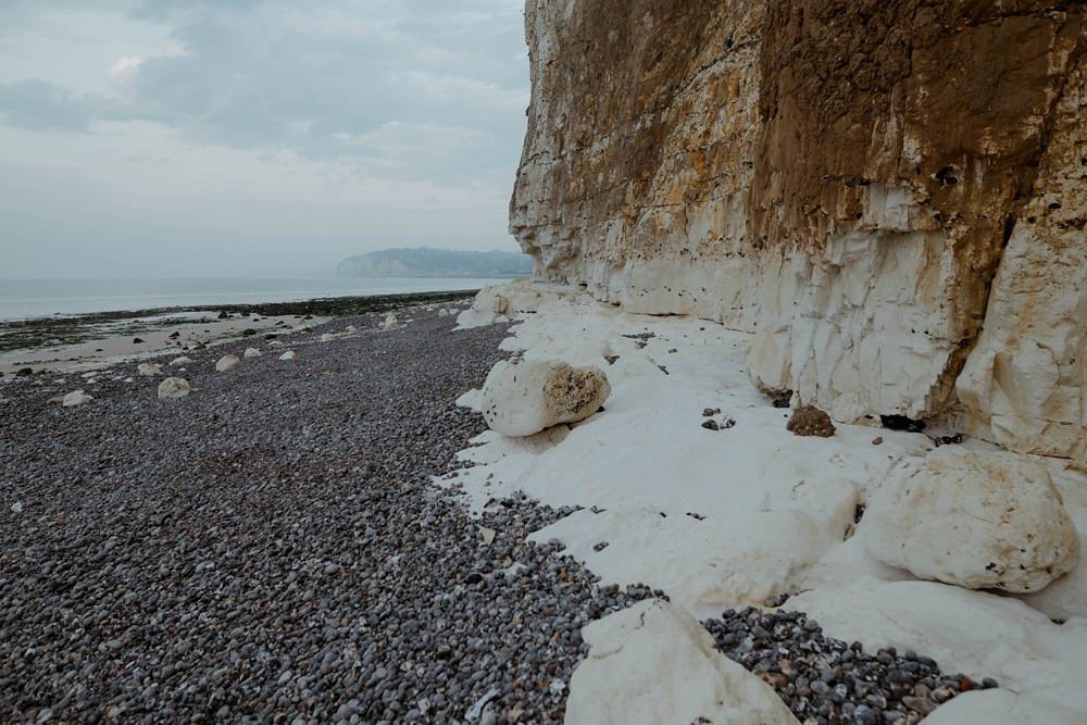 Séance photo en couple avant le mariage (shooting engagement) sur la plage de Dieppe à marée basse par Emmanuelle Auzou photographe à Dieppe